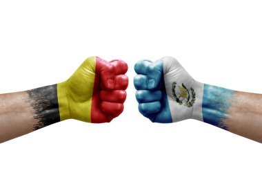 Two hands punch to each others on white background. Country flags painted fists, conflict crisis concept between belgium and guatemala