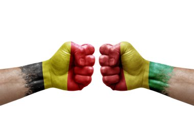 Two hands punch to each others on white background. Country flags painted fists, conflict crisis concept between belgium and guinea