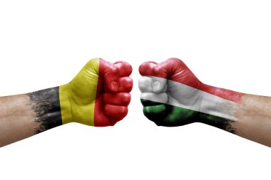 Two hands punch to each others on white background. Country flags painted fists, conflict crisis concept between belgium and hungary