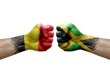 Two hands punch to each others on white background. Country flags painted fists, conflict crisis concept between belgium and jamaica