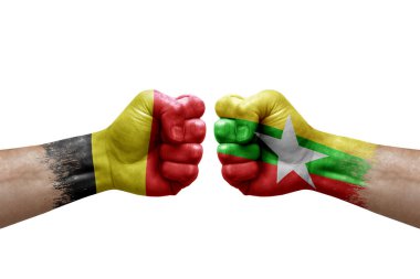 Two hands punch to each others on white background. Country flags painted fists, conflict crisis concept between belgium and myanmar