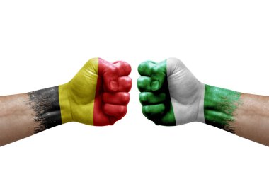 Two hands punch to each others on white background. Country flags painted fists, conflict crisis concept between belgium and nigeria