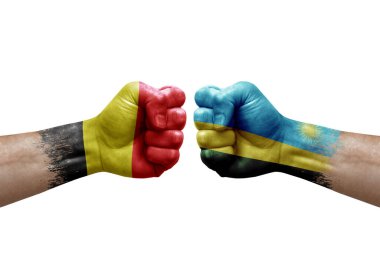 Two hands punch to each others on white background. Country flags painted fists, conflict crisis concept between belgium and rwanda