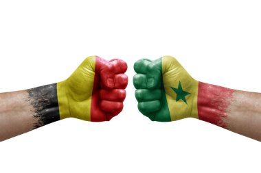Two hands punch to each others on white background. Country flags painted fists, conflict crisis concept between belgium and senegal