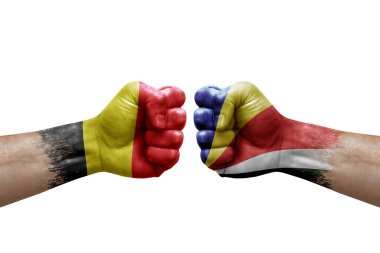 Two hands punch to each others on white background. Country flags painted fists, conflict crisis concept between belgium and seychelles