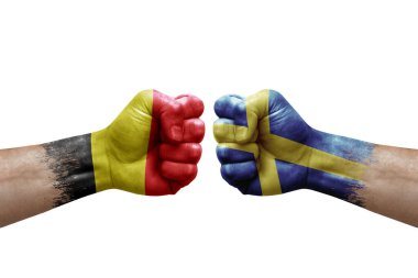 Two hands punch to each others on white background. Country flags painted fists, conflict crisis concept between belgium and sweden