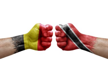 Two hands punch to each others on white background. Country flags painted fists, conflict crisis concept between belgium and tobago