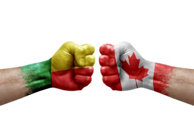 Two hands punch to each others on white background. Country flags painted fists, conflict crisis concept between benin and canada