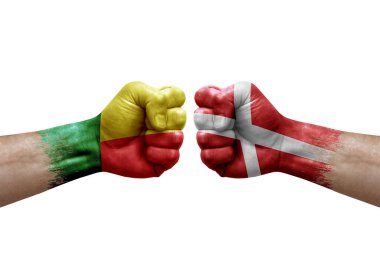 Two hands punch to each others on white background. Country flags painted fists, conflict crisis concept between benin and denmark