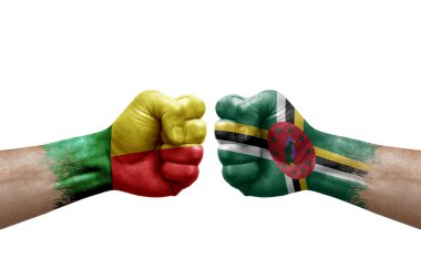 Two hands punch to each others on white background. Country flags painted fists, conflict crisis concept between benin and dominica