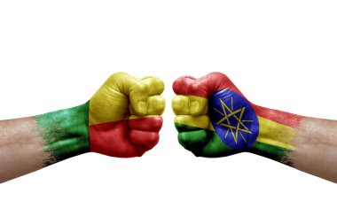 Two hands punch to each others on white background. Country flags painted fists, conflict crisis concept between benin and ethiopia