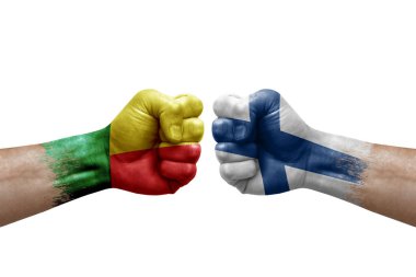 Two hands punch to each others on white background. Country flags painted fists, conflict crisis concept between benin and finland