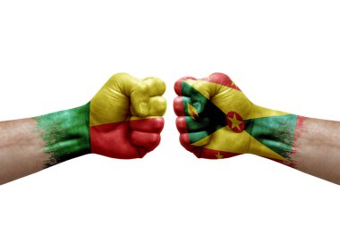 Two hands punch to each others on white background. Country flags painted fists, conflict crisis concept between benin and grenada