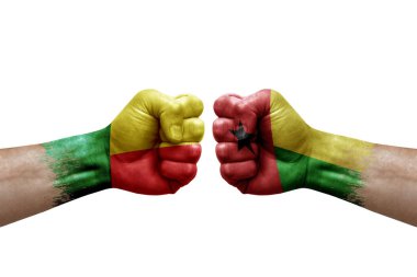 Two hands punch to each others on white background. Country flags painted fists, conflict crisis concept between benin and guinea-bissau