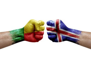 Two hands punch to each others on white background. Country flags painted fists, conflict crisis concept between benin and iceland