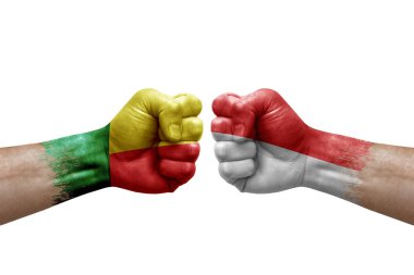 Two hands punch to each others on white background. Country flags painted fists, conflict crisis concept between benin and indonesia