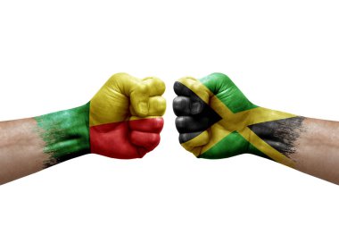 Two hands punch to each others on white background. Country flags painted fists, conflict crisis concept between benin and jamaica