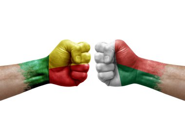 Two hands punch to each others on white background. Country flags painted fists, conflict crisis concept between benin and madagascar