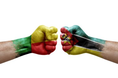 Two hands punch to each others on white background. Country flags painted fists, conflict crisis concept between benin and mozambique