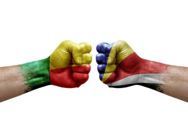 Two hands punch to each others on white background. Country flags painted fists, conflict crisis concept between benin and seychelles
