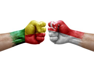 Two hands punch to each others on white background. Country flags painted fists, conflict crisis concept between benin and singapore
