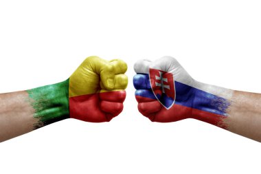 Two hands punch to each others on white background. Country flags painted fists, conflict crisis concept between benin and slovakia