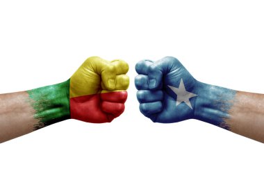 Two hands punch to each others on white background. Country flags painted fists, conflict crisis concept between benin and somalia