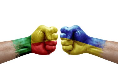 Two hands punch to each others on white background. Country flags painted fists, conflict crisis concept between benin and ukraine