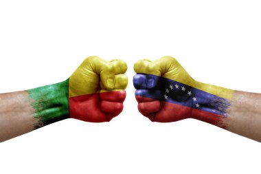 Two hands punch to each others on white background. Country flags painted fists, conflict crisis concept between benin and venezuela