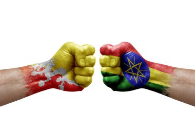 Two hands punch to each others on white background. Country flags painted fists, conflict crisis concept between bhutan and ethiopia