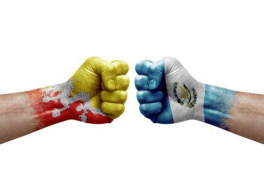 Two hands punch to each others on white background. Country flags painted fists, conflict crisis concept between bhutan and guatemala