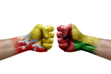 Two hands punch to each others on white background. Country flags painted fists, conflict crisis concept between bhutan and guinea-bissau