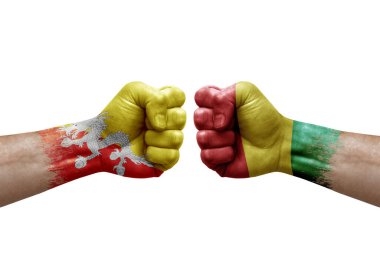 Two hands punch to each others on white background. Country flags painted fists, conflict crisis concept between bhutan and guinea