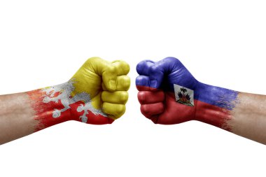 Two hands punch to each others on white background. Country flags painted fists, conflict crisis concept between bhutan and haiti