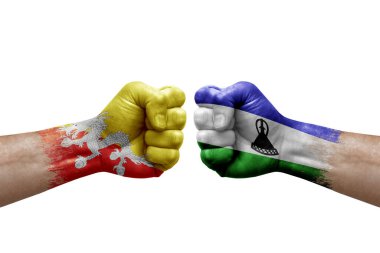 Two hands punch to each others on white background. Country flags painted fists, conflict crisis concept between bhutan and lesotho