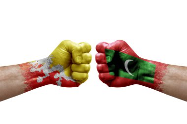Two hands punch to each others on white background. Country flags painted fists, conflict crisis concept between bhutan and maldives