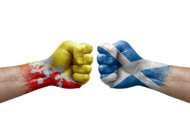 Two hands punch to each others on white background. Country flags painted fists, conflict crisis concept between bhutan and scotland