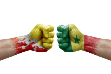 Two hands punch to each others on white background. Country flags painted fists, conflict crisis concept between bhutan and senegal