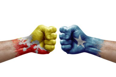 Two hands punch to each others on white background. Country flags painted fists, conflict crisis concept between bhutan and somalia