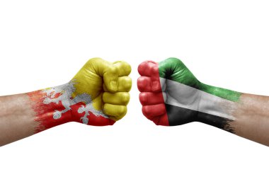 Two hands punch to each others on white background. Country flags painted fists, conflict crisis concept between bhutan and united arab emirates