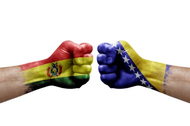 Two hands punch to each others on white background. Country flags painted fists, conflict crisis concept between bolivia and bosnia