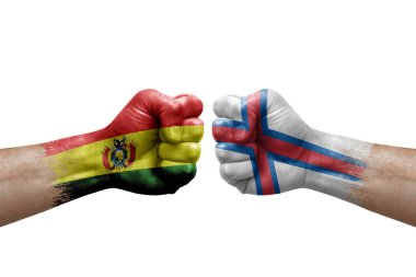 Two hands punch to each others on white background. Country flags painted fists, conflict crisis concept between bolivia and faroe islands