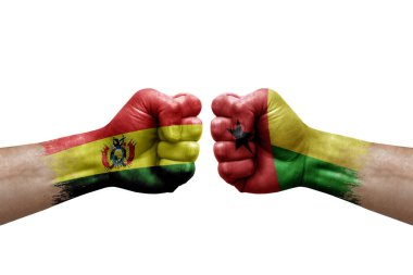 Two hands punch to each others on white background. Country flags painted fists, conflict crisis concept between bolivia and guinea-bissau