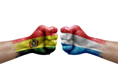 Two hands punch to each others on white background. Country flags painted fists, conflict crisis concept between bolivia and luxembourg