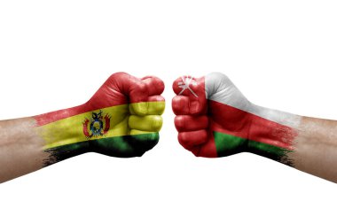 Two hands punch to each others on white background. Country flags painted fists, conflict crisis concept between bolivia and oman