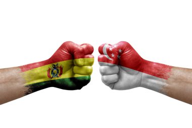 Two hands punch to each others on white background. Country flags painted fists, conflict crisis concept between bolivia and singapore
