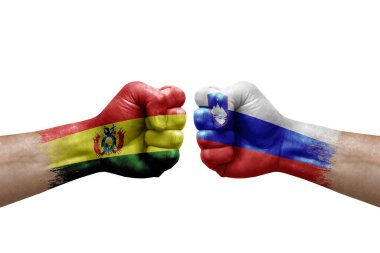 Two hands punch to each others on white background. Country flags painted fists, conflict crisis concept between bolivia and slovenia