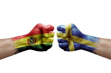 Two hands punch to each others on white background. Country flags painted fists, conflict crisis concept between bolivia and sweden