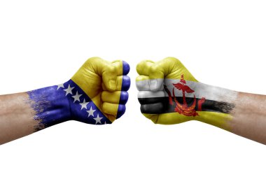 Two hands punch to each others on white background. Country flags painted fists, conflict crisis concept between bosnia and brunei