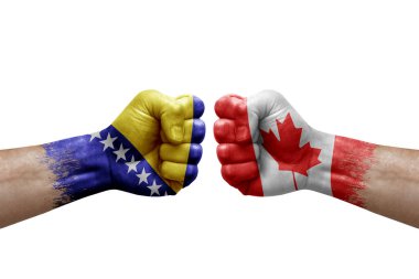 Two hands punch to each others on white background. Country flags painted fists, conflict crisis concept between bosnia and canada
